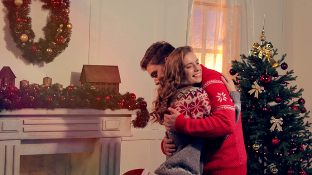 счастливая молодая пара в свитерах празднует Рождество вместе
 - Кадры, видео