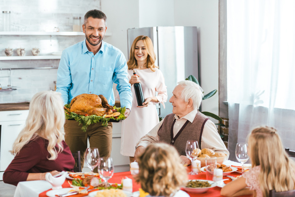 famille heureuse avec dinde célébrant jour de Thanksgiving à la maison
 - Photo, image