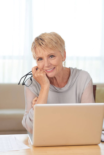 Kokenut hymyilevä liiketoiminnan nainen kannettavassa tietokoneessa
 - Valokuva, kuva