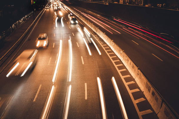 Night car traffic. Motion blur car viewed from the road bridge in big modern city. - Foto, Bild
