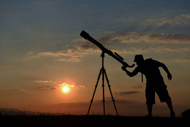 mies tarkkailee planeettaa ja tähtiä kaukoputkella aamuun asti
 - Valokuva, kuva