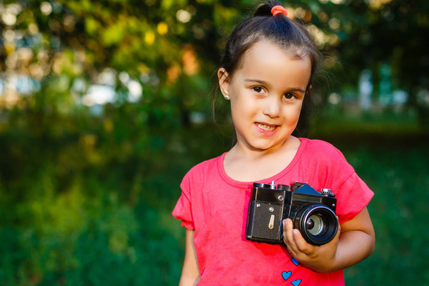 Porträt eines kleinen schönen Kindes mit Retro-Kamera.  - Foto, Bild