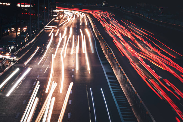 Tráfico nocturno. Motion desenfoque coche visto desde el puente de carretera en la gran ciudad moderna
. - Foto, Imagen