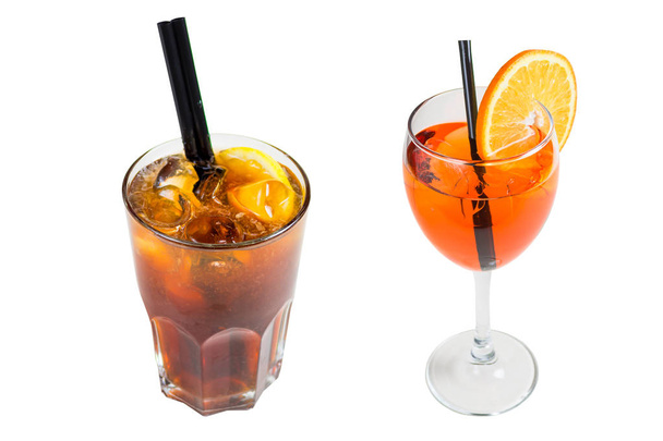 Two drinks, dark cocktail with ice in a glass and orange in a glass with a slice of orange, isolated on white background - Φωτογραφία, εικόνα