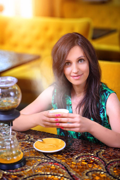 woman in a cafe is drinking exquisite tea - Fotó, kép