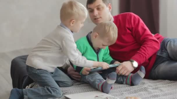 Heavy competition between brothers behind a tablet pc. - Materiał filmowy, wideo