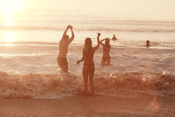 Silhouetten glücklicher Menschen, die Spaß am Strand haben, Sommerurlaub - Foto, Bild
