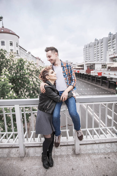 portrait of loving couple standing on bridge in big city - Foto, Imagen