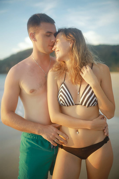 lovers at sandy beach, young guy and woman relaxing on the sea coast, the concept of summer holidays, vacation at sea - Foto, Imagem