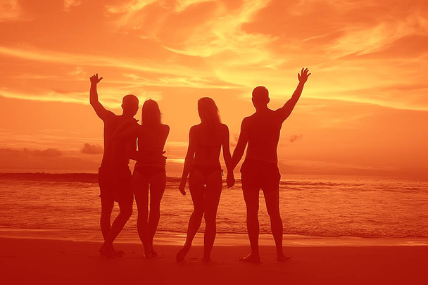 чотири друзі на пляжі, літні канікули та концепція щастя. Молоді чоловіки і жінки розважаються на морському березі
 - Фото, зображення