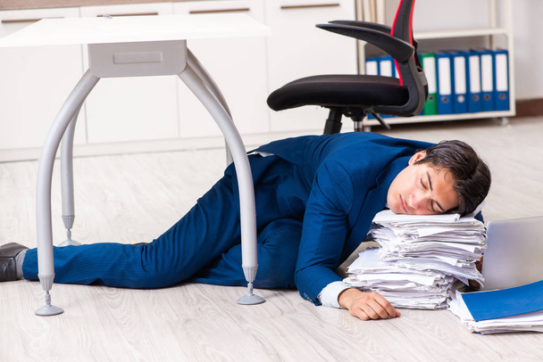 Fáradt, kimerült üzletember túlórázik az irodában. - Fotó, kép
