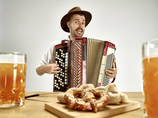 Man in traditional bavarian clothes playing accordion. Oktoberfest - Foto, afbeelding