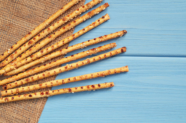 Palitos de pan con semillas de sésamo en la mesa de madera azul, vista superior con espacio para copiar
 - Foto, imagen