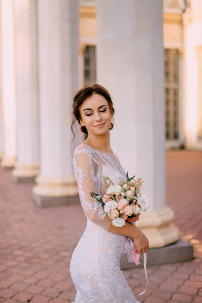 portrait of a young bride in background of columns - Φωτογραφία, εικόνα
