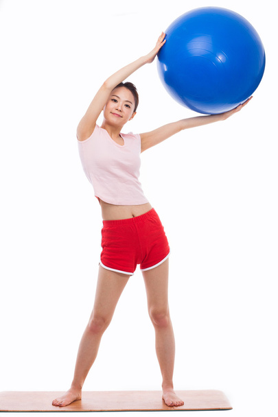 Young woman with gym ball isolated on white - Photo, image