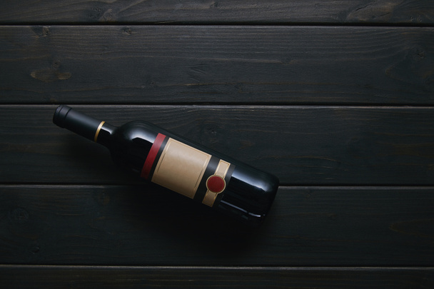 vue du dessus d'une bouteille de vin simple avec étiquette vierge sur une surface en bois
 - Photo, image