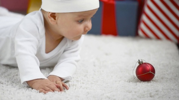 愛らしい赤ちゃんのクリスマス コンセプト ホワイト カーペット、自宅でクリスマス グッズにクロール - 映像、動画