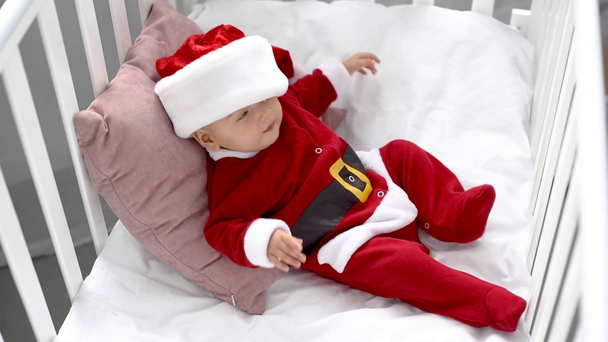 mothe kiinnityshattu ihana vauva joulupukki vauvansängyssä kotona, joulun käsite
 - Materiaali, video
