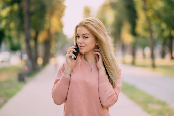 young girl speaks on phone outdoor - Valokuva, kuva