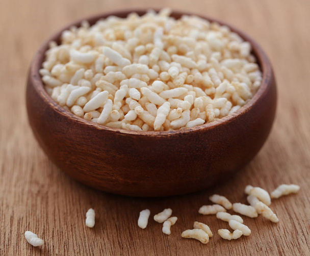 Fresh puffed rice in a wooden bowl on natural surface - Photo, Image