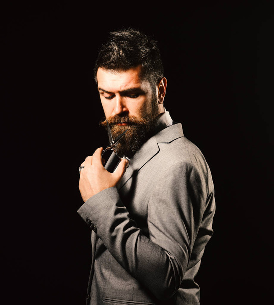 Man with beard holds steel scissors. Business and barbershop service - 写真・画像