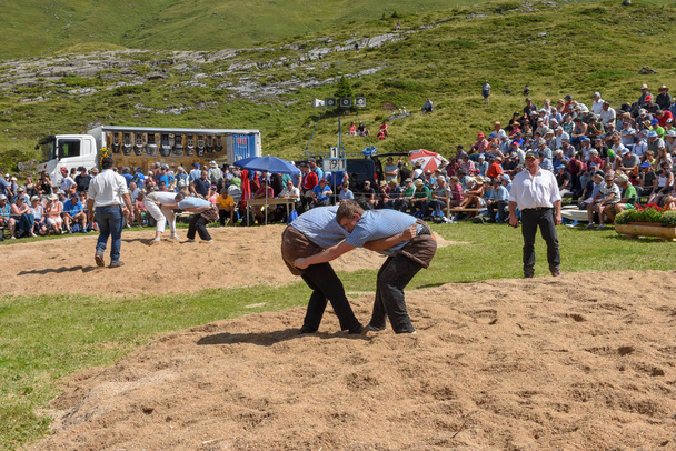 Engstlenalp, Switzerland - 4 August 2018: Two Swiss taking part in a traditional wrestling match (called 'Schwingen') at Engstlenalp on the Swiss alps - Photo, Image