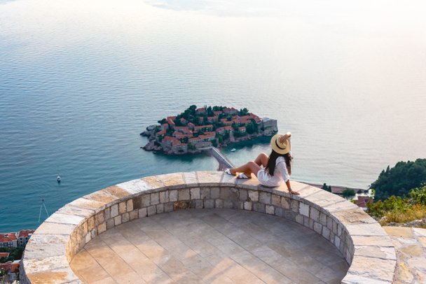 femme assise sur le belvédère près de l'île de Saint Stephen dans la mer Adriatique, Budva, Monténégro
 - Photo, image