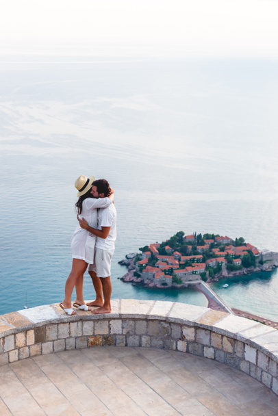 couple câlin sur le belvédère près de l'île de Sveti Stefan avec hôtel station balnéaire dans la mer Adriatique, Budva, Monténégro
 - Photo, image