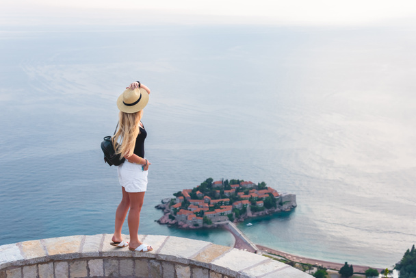 femme debout et regardant saint stephen île dans la mer Adriatique, Budva, Monténégro
  - Photo, image
