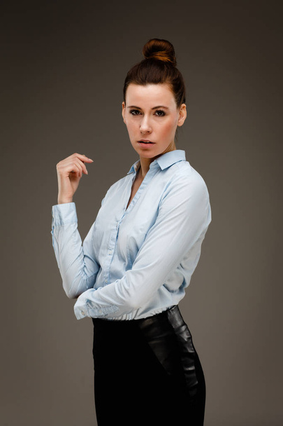 Businesswoman in blue shirt and black skirt posing in studio - Valokuva, kuva