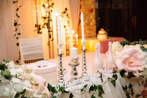 El concepto de una celebración de la boda, la celebración de los amantes, decoración, flores, telas. La mesa de los recién casados está decorada con flores, velas y telas.
. - Foto, Imagen