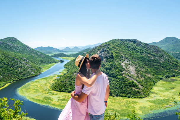 girlfriend kissing boyfriend near Crnojevica River (Rijeka Crnojevica) in Montenegro - Photo, Image