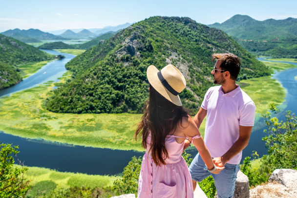 pár v růžové oblečení, drželi se za ruce a při pohledu na Cmojevica nabízí turistům řeky v Černé hoře - Fotografie, Obrázek