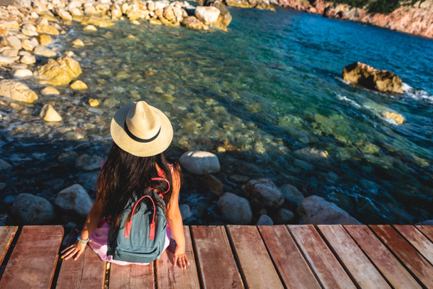 vue arrière de la femme assise sur un pont près de la mer à Budva, Monténégro
 - Photo, image
