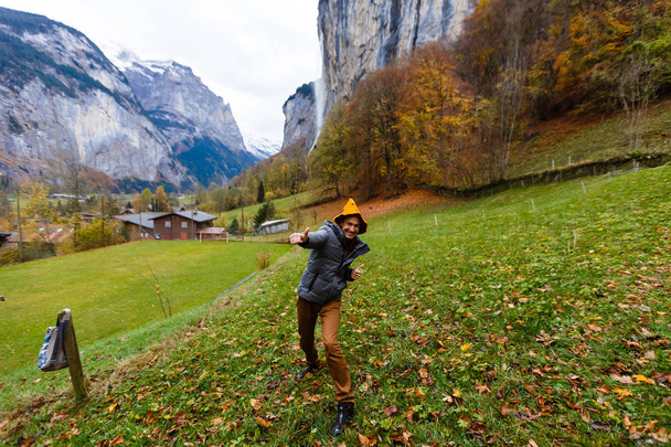 knappe man met Halloween hoed poseren in lauterbrunnen in Zwitserland met panoramisch uitzicht op de Zwitserse Alpen - Foto, afbeelding