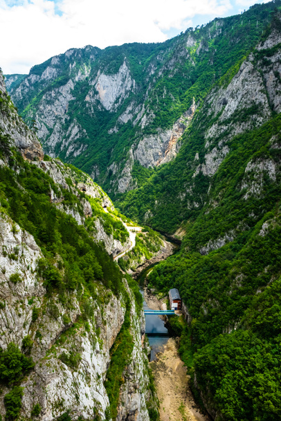 Luftaufnahme der Brücke zwischen Bergen und Haus in Piva-Schlucht in Montenegro - Foto, Bild