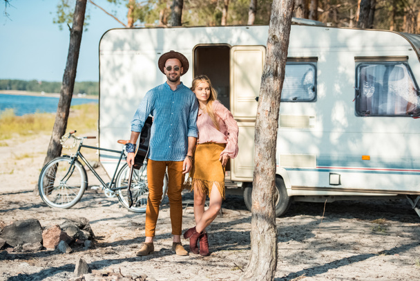 young couple of campers posing near trailer - Foto, imagen