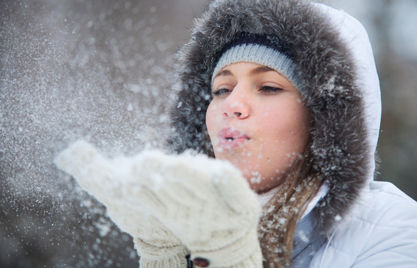 Beautiful woman blowing in the snow - Фото, зображення