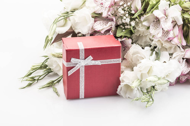 eine rote Geschenkschachtel und Blumen auf weiß mit Kopierraum - Foto, Bild
