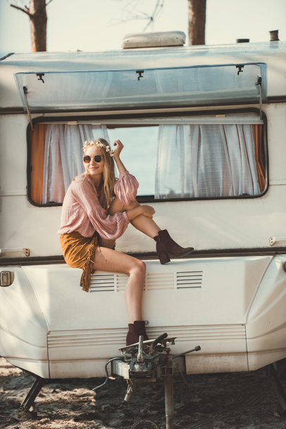 hippie κορίτσι στο στεφάνι και γυαλιά ηλίου καθισμένος σε campervan - Φωτογραφία, εικόνα