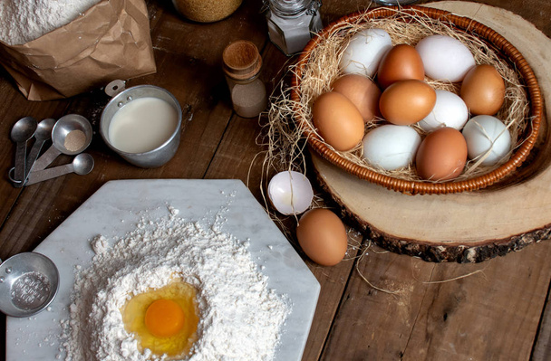 Eggs, dough and flour on wooden table with splat background for an object in a bakery,Food concept. - Фото, изображение