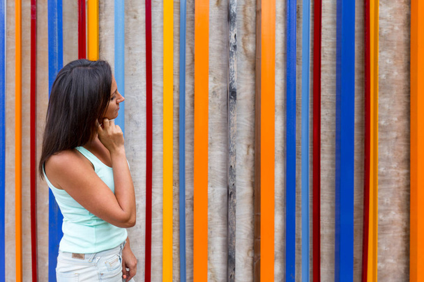 Concept design thinking. The brunette girl thinks about the idea of how to paint a wooden wall. - 写真・画像