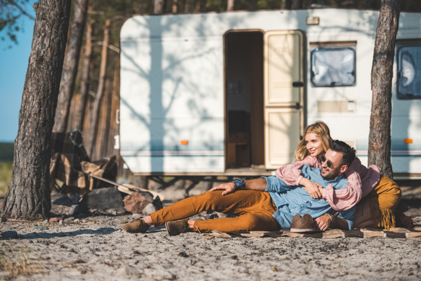 hippie young couple relaxing on blanket near camper van - Foto, imagen