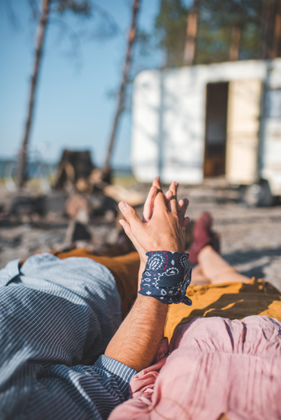 cropped view of couple holding hands and relaxing near trailer  - Φωτογραφία, εικόνα