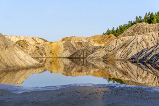paisaje lago en el fondo de una cantera gastada de la minería caolín con hermosas laderas con rastros de arroyos
 - Foto, imagen