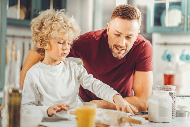 Bearded father helping his cute boy forming biscuits - Foto, Bild