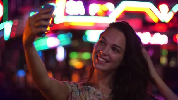 女性観光客が夜の selfie を撮影します。市光で selfie を作る美しい少女 - 映像、動画