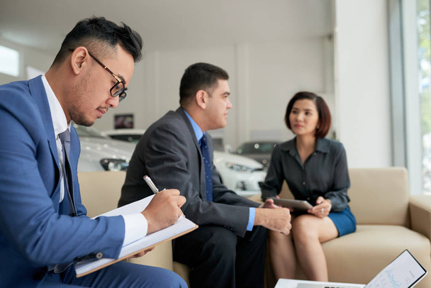 Азиатские финансовые менеджеры, анализирующие статистику и работающие в офисе
  - Фото, изображение