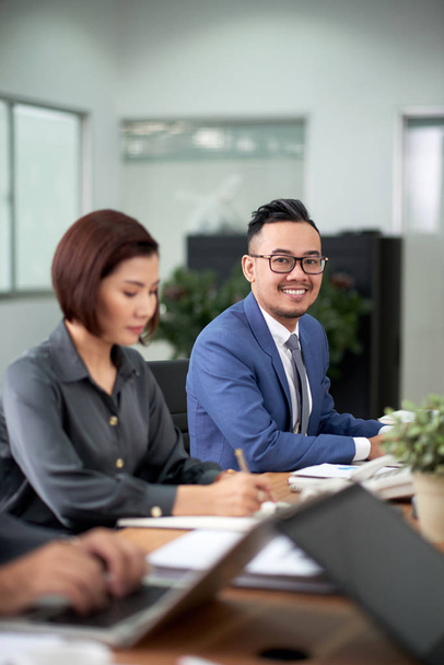 Dois empresários asiáticos no escritório trabalhando e sorrindo
  - Foto, Imagem