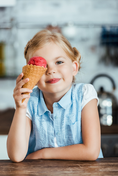 χαριτωμένο παιδί ευτυχισμένη κρατώντας νόστιμο γλυκό παγωτό χωνάκι και να χαμογελά στη φωτογραφική μηχανή  - Φωτογραφία, εικόνα